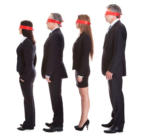 Four businessmen and women queuing with blindfolds on